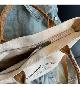 Detail of smooth black metal zipper closure on heavy-duty beige canvas tote bag