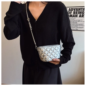 Detail of silver quilted chain bag with diamond stitching and metallic texture