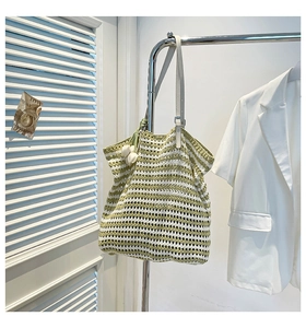 Detail of green and beige striped knit tote bag with delicate tulip charms and mesh texture