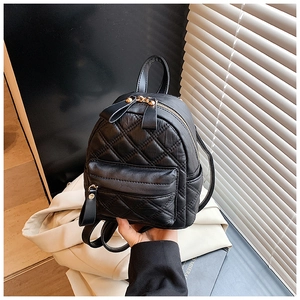 Detail of black quilted mini backpack with gold zippers and premium faux leather texture