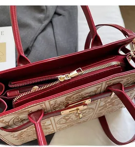 Detailed close-up of smooth metal zipper and golden twist lock on embroidered handbag