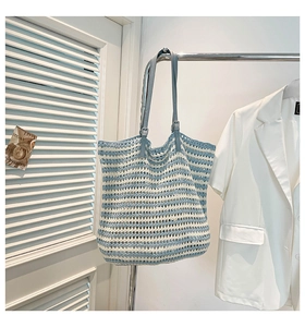 Close-up of blue and white striped crochet tote bag with adjustable blue leather strap