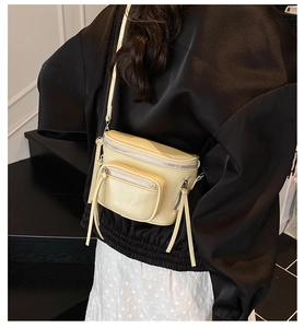 Vue détaillée du sac selle en cuir jaune crème porté par un mannequin en intérieur