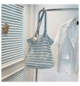 Detail of blue and white striped woven tote bag with a white tulip charm and leather strap