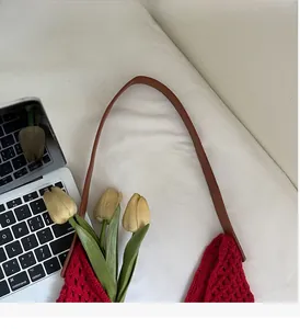 Detail of red hollow crochet knit tote bag with premium brown leather handle and strap