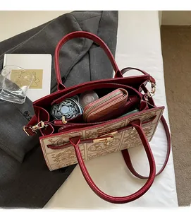 Top view of spacious interior of embroidered tote bag holding umbrella and cosmetics
