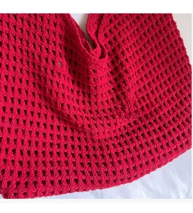Detailed close-up of the red knitted mesh fabric texture on the summer crochet tote bag