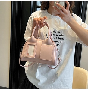 Pink shiny patent leather Boston bag with decorative card slot shown in a mirror selfie