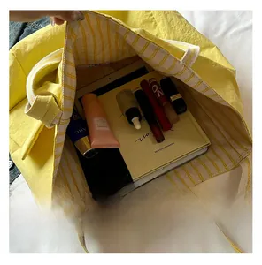 Macro view of the yellow tote bag interior featuring large capacity and striped lining