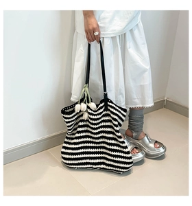 Detail of crochet striped tote bag with black leather straps and tulip decor