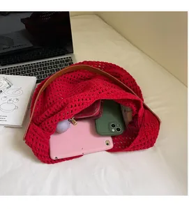 Macro detail of red hollow knit tote bag showing spacious interior with leather handles