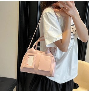 Detailed shot of pink patent leather handbag with glossy finish and front decorative pocket