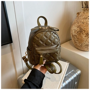 Detailed shot of an olive green quilted mini backpack with a decorative bow and gold zippers