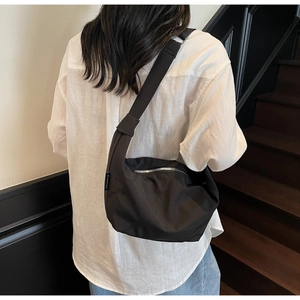 Detail der schwarzen Nylon-Tasche mit Ziyouse-Webetikett und silbernem Reißverschluss