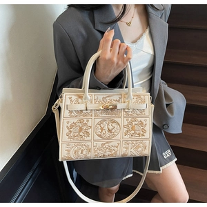Detail of embroidered crossbody bag with floral patterns and polished metal swivel lock