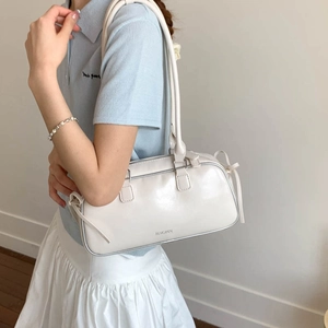 Detailed view of the JINGPIN logo and polished white wax leather finish on the baguette bag