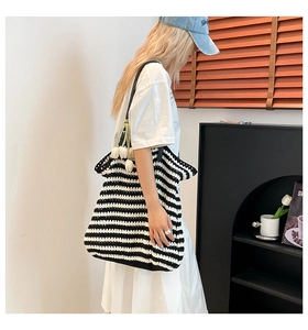 Detailed knit texture of black and white striped crochet tote bag with tulip charm