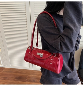 Close-up of red patent leather bowling bag with silver heart lock and rivet details