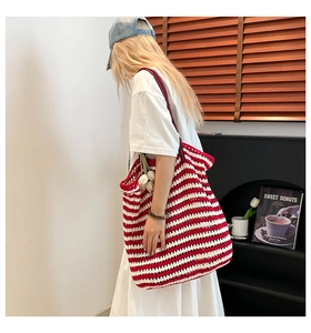 Close-up of red and white striped knit tote bag with thick cotton texture and red straps