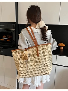 Grand sac cabas en paille tressée beige avec anses en cuir marron et pendentif ours