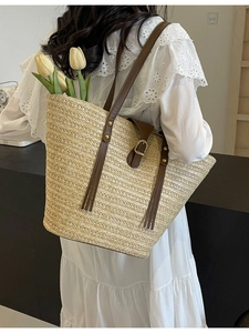Large straw tote bag with brown leather straps for summer fashion and travel
