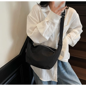 Detail der schwarzen Nylon-Tasche mit silberner Metallschnalle und verstellbarem Gurt
