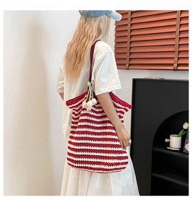 Detail of red and white striped knit tote bag with a white tulip flower charm accessory