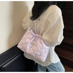 Detail view of lavender quilted crossbody bag with diamond star and chain strap