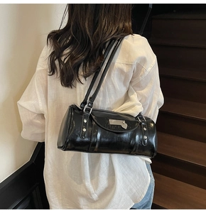 Fashionable black glossy bowling shoulder bag styled with a white linen shirt