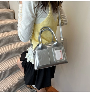 Detail of silver metallic crossbody bag with unique clear card slot and sleek design