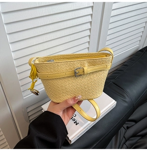 Dettaglio borsa a tracolla gialla con trama intrecciata e cinturino decorativo