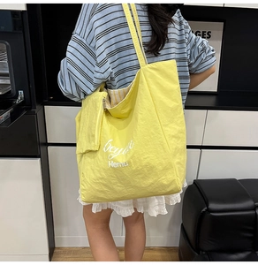 Detail of a bright yellow tote bag with a small matching zip pouch for students