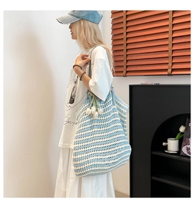 Detail of a large striped knit tote bag with tulip charm shown in a lifestyle setting
