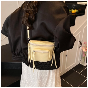 Vue détaillée arrière d'un sac seau crème avec fermetures éclair à pompons stylés