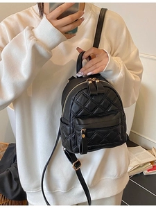 Chic black quilted mini backpack with gold hardware worn by a model in a modern style