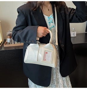 Detail of cream white Boston bag featuring a front card slot and detachable shoulder strap