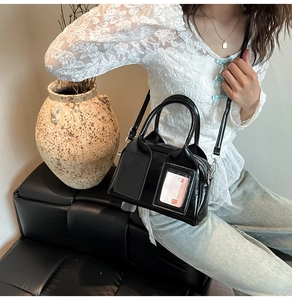 Detail of glossy black patent leather bag with transparent card slot and slim strap