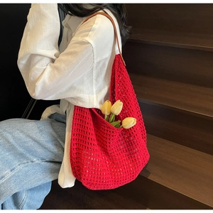 Detail of red hollow knit tote bag featuring premium brown leather shoulder straps
