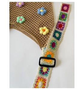 Detail of hollow knit tote with 3D crochet flowers and vibrant granny square strap