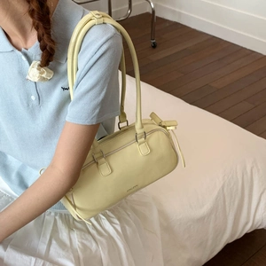 Side view of yellow faux leather baguette bag worn with a casual spring outfit