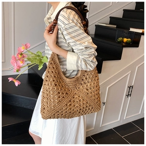 Detail of hollow-out straw tote bag featuring dark wood bead handle and woven texture