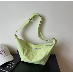 Detail der avocado-grünen Nylon-Halbmondtasche mit silbernem Reißverschluss und Gurt