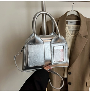 Detail of silver Boston bag with twin handles and transparent card slot accessory
