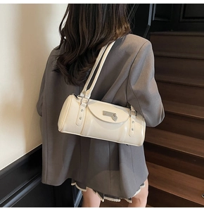 Detail of the cream white bowling bag showing shiny leather and metal hardware