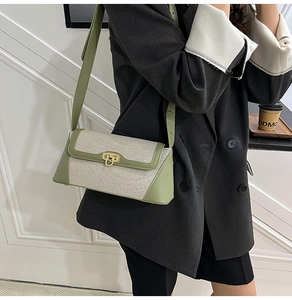 Detail of canvas and green leather crossbody bag with vintage gold metallic lock