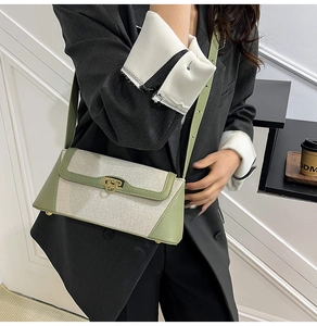 Detail of the woven canvas and green leather shoulder bag worn by model