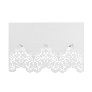 Macro detail of laser-cut lace pattern on white pearlescent paper wedding place card