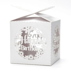 Macro detail of laser-cut flower patterns and Happy Birthday text on white gift box