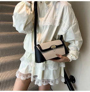 Detail of a minimalist canvas and leather shoulder bag shown on a model for scale