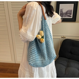 Detail of light blue crochet woven tote bag with yellow tulips and brown leather straps